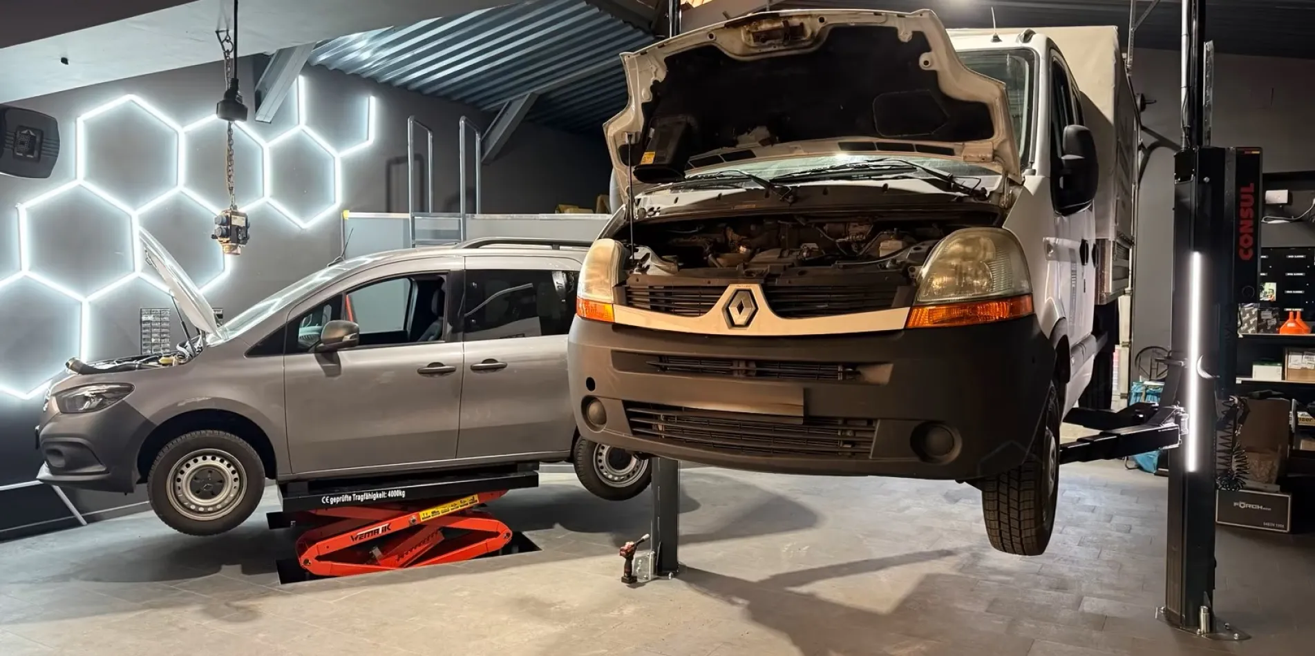 Kfz Mechatroniker Job in Halle Fahrzeug auf Hebebühne bei Reparatur in moderner Werkstatt